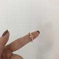Bague ouverte dorée avec perles et fleur en croix en zircon marquise sur la main - Bague Fleur en Zircone