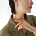 Silver lock-shaped earrings with a round purple gemstone on a model in a green blazer - Earrings-Purple Zirconia / Steel