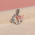 Macro shot of silver ring pendant with pink glitter butterfly and blue enamel flower detail - Silver Butterfly