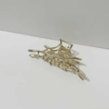 Detail of a gold metal spider web hair claw clip on a clean neutral background - Spiderweb Hair Claw / Gold