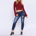 Dettaglio dei jeans slim blu scuro con strappi sulle ginocchia e finitura lavata moda - S / Blu scuro