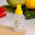 Mini portable plastic squeeze bottle for salad dressing with yellow lid on a wooden board - Salad Single Bulk