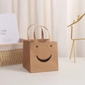 Geschenktüte aus braunem Kraftpapier mit lachendem Gesichtsausschnitt und Tragegriffen - Smiley Natur 10x10x10cm