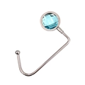 Tragbarer Metalltaschenhaken mit facettiertem blauem Edelstein auf weißem Grund - Wasserblau