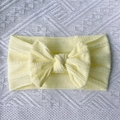 Detail of soft yellow knitted nylon baby headband with textured twist bow knot - Beige