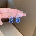 Zilveren naald oorbellen met blauwe druppelkristal en roze vlinder accenten - Blauw