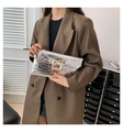 Detail of silver crocodile pattern clutch bag with gold buckle on brown blazer - Silver