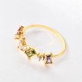 Macro shot of minimalist gold ring with colorful rectangular and round gemstones on silk - US 6 / Four Stones