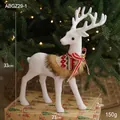 White reindeer Christmas ornament with red knit scarf and gold bells on gift box - Looking Back Reindeer