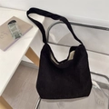 Detail of black corduroy tote bag with wide strap and soft texture on a chair - Black