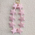 Pink star-shaped silicone bead keychain with a gold metal ring on plush fabric - Cool Light Pink (10 Stars)