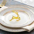 Gouden rendier servetring van metaal op een wit bord voor een feestelijke tafelsetting - Goud Rennend Hert