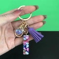 Detail of resin tassel keychain featuring purple glitter globe and colorful stone pendant - Letter I