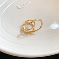Macro shot of minimalist gold double-layered spiral ring on a textured white plate - Ring (Gold) / Gold