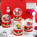 Christmas snow globe with Santa and reindeer figures, red base with light and snow feature - 6hs58# (lights + Snowflakes) / 65# (cardboard Box Packaging)