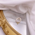 Detailed macro of a freshwater pearl ring featuring a golden letter P pendant on mirror - Letter P