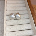 Close-up of small silver-colored C-shaped earrings with a matte brushed metal finish - Silver (925 Sterling Silver Pin)