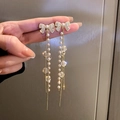 Golden bow earrings with pearl tassel and crystal beads held by hand for display - 17# Silver Needle - Alloy - Gold Bow Tassel