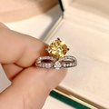 Dettaglio macro dell'anello a corona con gemma gialla taglio princess e ali in pavé - US 7 / Giallo
