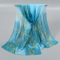 Détail d'une écharpe légère en mousseline bleue avec imprimé feuilles jaunes sur cintre - Modèle Châle Long (XQ440) / 150*50cm / Bleu avec Feuilles Jaunes