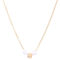 Detail of gold necklace with two white pearls and one matte textured metallic center bead - Necklace / Gold