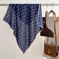 Dettaglio di un foulard blu navy stampato appeso accanto a un blazer bianco e borsa in pelle - 68*68cm / Blu