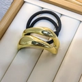 Detalle macro de la goma de pelo de metal dorado ondulado en bandeja de joyería - Estilo A-Ondulado Liso