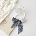Detailed shot of pearl necklace with blue floral silk ribbon bow on art book background - Dark Blue Paisley Floral