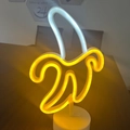Banana-shaped LED neon light with yellow peel and white fruit on a round white base - 2023 New Banana