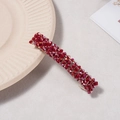 Détail des perles en cristal rouge foncé sur une pince à cheveux dorée pour femme - Rouge Foncé