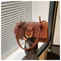 Close-up of brown crocodile texture handbag with twisted handle and golden U-shaped buckle - Brown