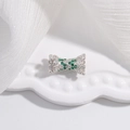 Détail macro d'un charm nœud argenté avec cristaux verts et blancs sur céramique - Style B - Design Sablier (SK51) / Argent 925 / 8*15.3mm / Zirconia vert plaqué rhodium