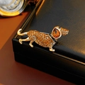 Macro shot of a golden dachshund brooch with amber rhinestones on a black leather box - Amber Rhinestone Dachshund Style (36#)