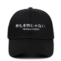 Détail de la broderie blanche Nothing Is Real sur une casquette en sergé de coton noir - Noir