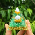 Orgone pyramid with green stones and lotus held in hand over natural background - Style 14