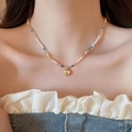 Gros plan d'un collier de perles doux avec un pendentif cœur doré porté sur le cou - 27# Collier de perles en forme de cœur 3D doré
