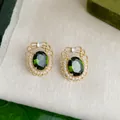 Orecchini vintage dorati con gemma verde e perle su sfondo in lino beige - 2778 Farfalla in pizzo strass