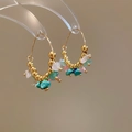 Dettaglio di orecchini a cerchio dorati con pietre naturali turchesi, rosa e bianche - Oro-Multicolore