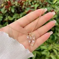 Detail of heart-shaped hollow gold pendant with inlaid white pearls on beaded chain - White 1 (Small Heart)