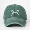 Close-up of white bow embroidery on a vintage washed green cotton baseball cap - One Size / Dark Green