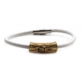 Dettaglio macro del bracciale in pelle intrecciata bianca con ciondolo a fleur-de-lis - A Oro