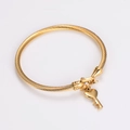 Détail macro du bracelet en fil d'acier spirale doré avec pendentif clé en forme de cœur - Or avec breloque clé