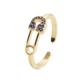 Eleganter goldener Sicherheitsnadel-Ring mit funkelnden blauen Zirkoniasteinen auf Weiß - Gold/Blauer Zirkonia
