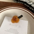 Close-up of amber rose acetate hair clip with gold France Handmade lettering on metal base - Caramel color