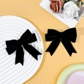 Primer plano de un par de pinzas para el cabello con lazo de terciopelo negro dulce - Negro