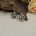 Detail view of two blue resin cube pendants with irregular gold-plated edges for DIY jewelry - Light Blue