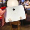 Orecchini a ghirlanda dorata con perle bianche tenuti in mano su sfondo caldo - Stile Corona di Perle (9#) / Oro