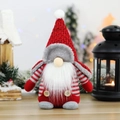 Gnomo di Natale in peluche con cappello rosso e corpo a righe su tavolo in legno - Stile Cappello a Punta