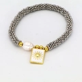 Dettaglio macro del bracciale bohémien con pendente a sole quadrato e perla naturale - Stile Rilievo Sole (05#)