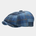 Dettaglio del berretto newsboy in lana a quadri blu che mostra la trama del tessuto vintage - Regolabile / Quadri Blu